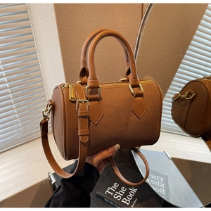 Detailed view of brown canvas Boston bag with leather straps and golden metal zippers