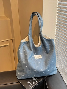 Light blue denim tote bag featuring white bow patterns and a large capacity for daily use