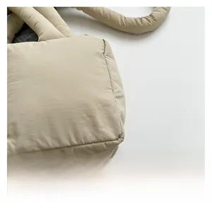 Gros plan du sac cabas matelassé beige montrant la texture du tissu en nylon rembourré