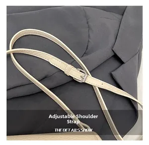 Detail of adjustable litchi texture leather strap with silver metal pin buckle on cream bag
