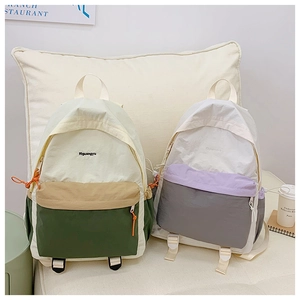 Detail of color-block waterproof nylon backpacks in mint and purple tones for travel