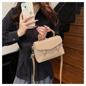 Detail shot of the khaki woven texture canvas crossbody bag with round snap buttons