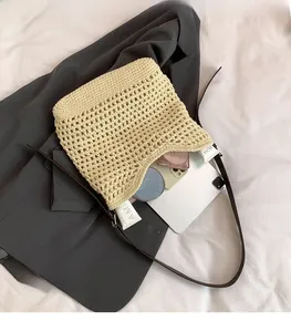 Détail d'un sac cabas en paille tressée avec intérieur spacieux et anses en cuir