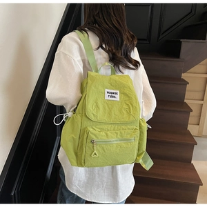 Zaino in tela verde chiaro con tasca anteriore con zip e dettagli applicati in testo