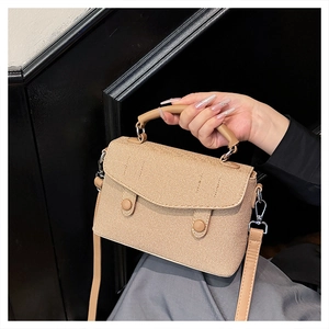 Close-up of khaki woven crossbody bag with circular buttons and round handle details