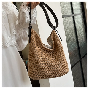 Détail d'un sac cabas tissé avec bandoulière en cuir marron et doublure grise