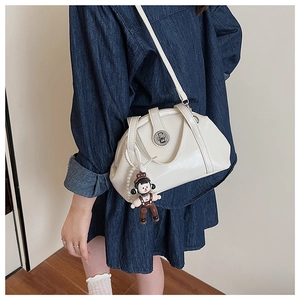 Sac bandoulière crème brillant avec breloque mignonne et chaîne en perles sur modèle