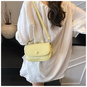 Close-up of pale yellow crossbody bag with lychee texture and silver metal hardware