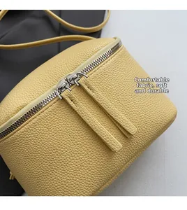Nahaufnahme der gelben Ledertasche mit Doppelreißverschluss und präzisen Nähten