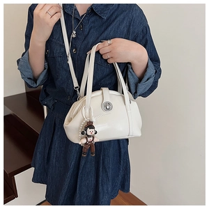 Détail du sac bowling en cuir PU blanc avec fermoir rotatif argenté et charm poupée