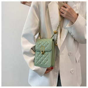 Detail of light green quilted crossbody bag with gold chain and adjustment ball