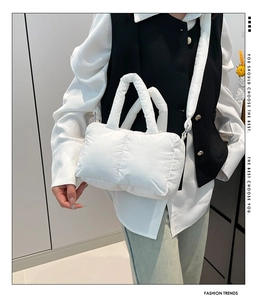 Détail du sac à main matelassé blanc avec texture douce et poignée rembourrée