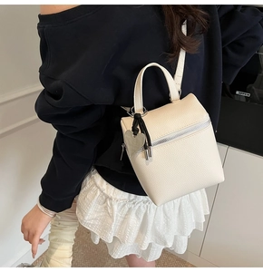 Secchiello beige a grana con pendente a cuore indossato da modella in un contesto reale