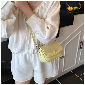 Detail of lime yellow saddle bag with lychee grain leather and silver metal hook