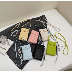 Vue à plat de sacs de téléphone colorés avec breloques d'ours en nuances vibrantes