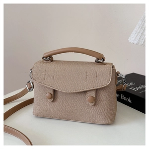 Detail of beige woven texture handbag with khaki leather flap and silver hardware