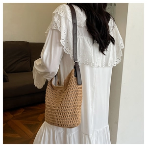 Détail de la texture en maille tissée main et bandoulière cuir du sac seau d'été