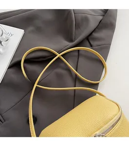 Detail der gelben Box-Tasche mit Lychee-Ledertextur und silbernem Reißverschluss-Akzent
