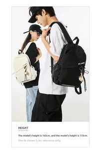 Borsa a tracolla sportiva nei colori nero e bianco sporco indossata da modelli uomo e donna