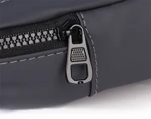Close-up of smooth black matte metal zipper on durable washed denim crossbody bag