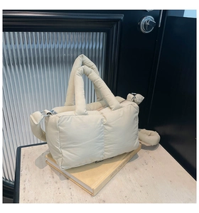 Détail du sac cabas matelassé beige montrant les poignées et la texture en nylon