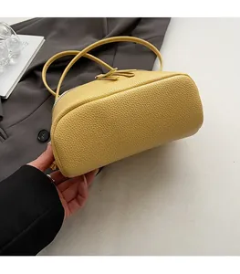 Detailaufnahme des flachen Bodens und der Lederstruktur der gelben Handtasche