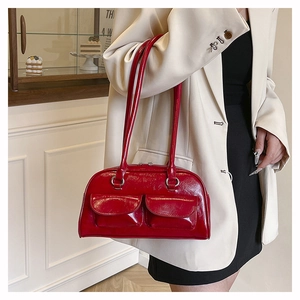 Détail du sac sous le bras rouge foncé vintage avec deux poches avant et cuir brillant