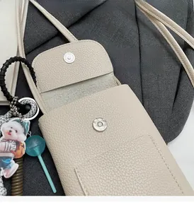 Détail du petit sac bandoulière crème avec texture grainée et fermoir magnétique