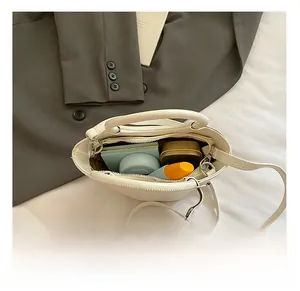Internal capacity of white croc-effect crossbody bag showing daily makeup storage
