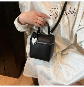 Dettaglio della mini borsa a secchiello in pelle nera con ciondolo a cuore in marmo