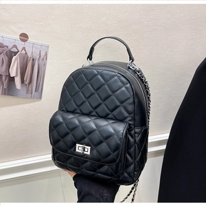Detailansicht eines gesteppten schwarzen Lederrucksacks mit Rautenmuster und Silberkette