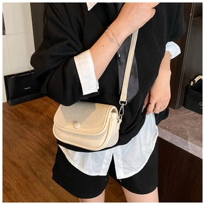 Detail of off-white lychee grain leather crossbody bag with flap and metal hook texture