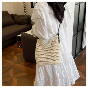 Détail d'un sac seau au crochet beige avec maille tissée et fine bandoulière en cuir marron