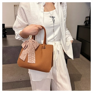 Détail du sac cabas en toile avec ruban à pois marron et fermeture à bouton pression