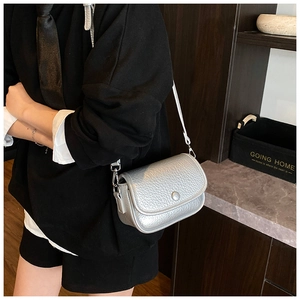 Detail of silver crossbody bag featuring litchi texture and sleek metallic finish