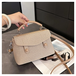 Close-up of khaki woven texture handbag with silver buttons and detachable shoulder strap