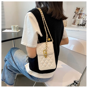 Detail view of a white quilted crossbody phone bag with a gold chain strap on a model