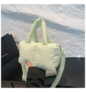 Détail du sac à main matelassé vert clair avec bandoulière large et zip argenté