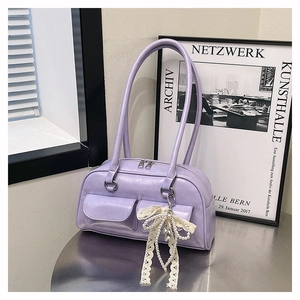 Détail du sac bowling lavande en cuir texturé avec un pendentif nœud en perles