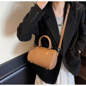 Detail view of mini brown canvas Boston bag with leather trim and gold hardware details