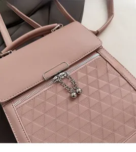 Detailed close-up of pink leather handbag featuring geometric triangle embossed patterns