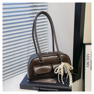 Détail du sac bowling marron foncé avec poches avant et pendentif en perles et dentelle
