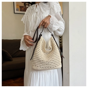 Détail d'un sac au crochet crème avec motif ajouré et bandoulière en cuir marron