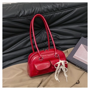 Détail du sac bowling en cuir rouge brillant avec poches avant et nœud en dentelle perlée