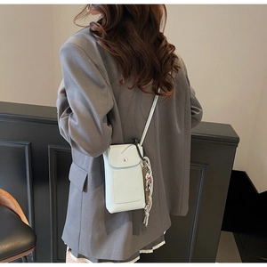 Détail du mini sac de téléphone en cuir bleu clair avec fermoir métal et pendentif tissé