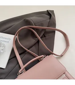 Pink leather handbag detail featuring soft double straps and metallic zipper accents