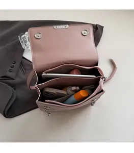 Pink crossbody bag interior showing multiple storage compartments and magnetic closures