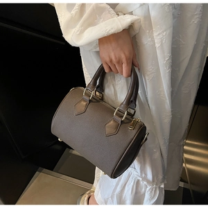 Detail of vintage canvas Boston bag with leather trim and gold-tone metal hardware