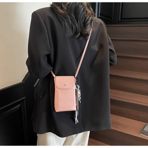 Vue détaillée du dos d'un petit sac bandoulière rose en cuir sur un mannequin