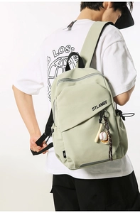Dettaglio borsa sportiva verde con ciondolo a forma di mazza da baseball e logo STLANGS
